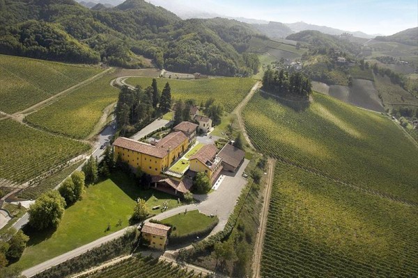 Vinárstvo obklopené vinicami a kopcovitou krajinou.