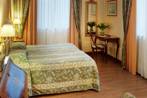 Elegantná spálňa s manželskou posteľou a dreveným nábytkom.