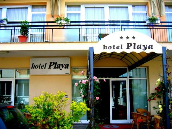 Vchod do hotela Playa s nápisom a kvetinovou výzdobou.