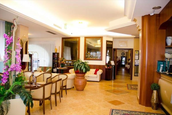 Elegantná hotelová lobby s pohodlným posedením a kvetinovou výzdobou.