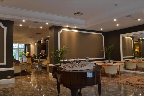Elegantná hotelová lobby s klavírom a pohodlnými sedačkami.