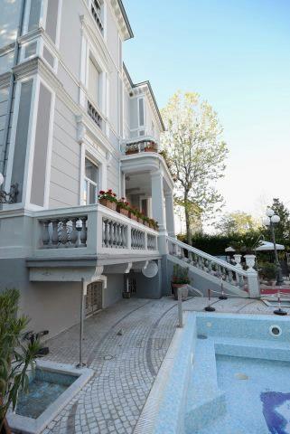 Luxusná vila s terasou a bazénom v záhrade.