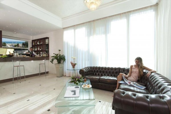 Elegantná hotelová lobby s koženým gaučom a barom.