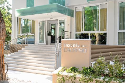 Vstup do moderného hotela s nápisom Hotel Calypso a štyrmi hviezdičkami.