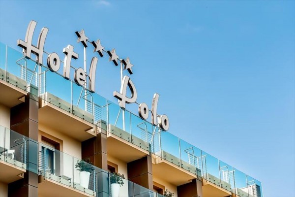 Hotel Polo so štyrmi hviezdičkami na modernej budove s balkónom.