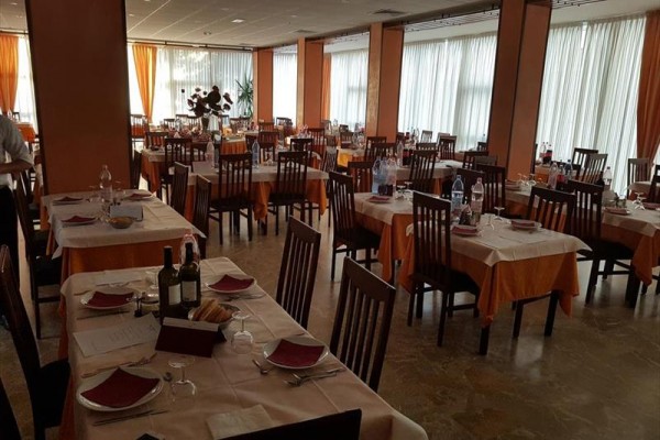 Reštaurácia s prestretými stolmi a stoličkami, pripravená na obsluhu hostí.