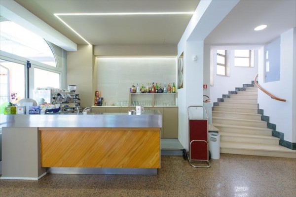 Bar s moderným dizajnom a schodiskom v pozadí.
