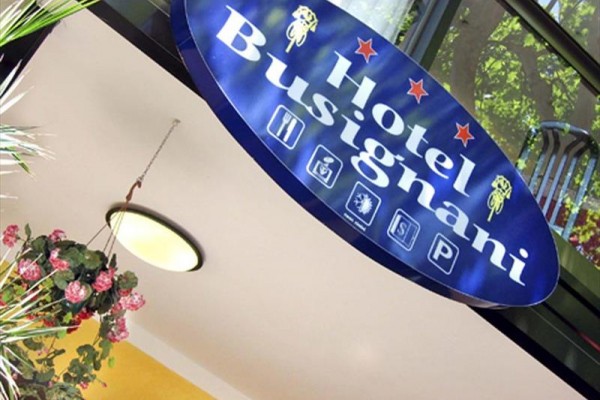 Modrá tabuľa s nápisom Hotel Busignani a štyrmi piktogramami.
