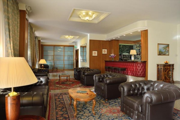 Elegantná hotelová lobby s koženými pohovkami a barom.  