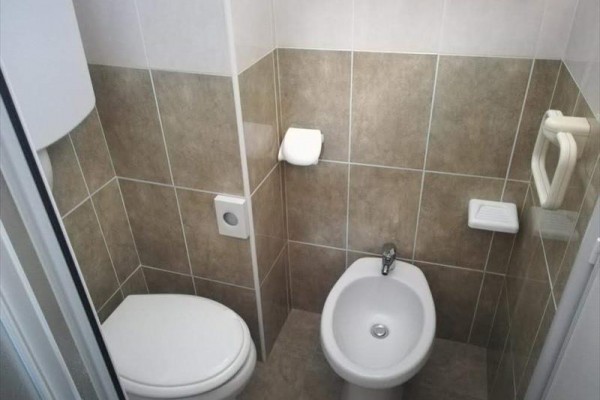 Toaleta s bidetom a béžovými obkladmi.