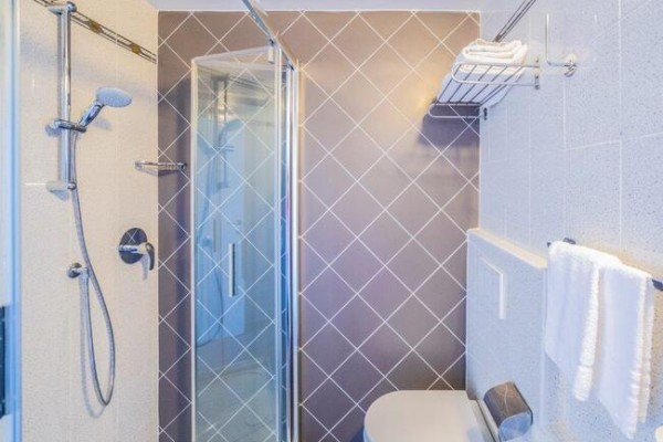 Moderná kúpeľňa so sprchovacím kútom a toaletou.