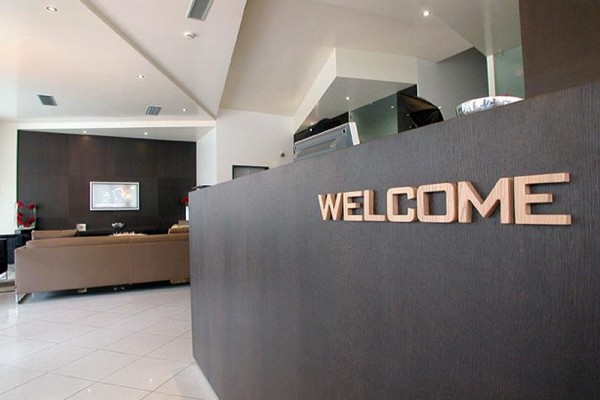 Moderná recepcia s nápisom „WELCOME“ na pulte.