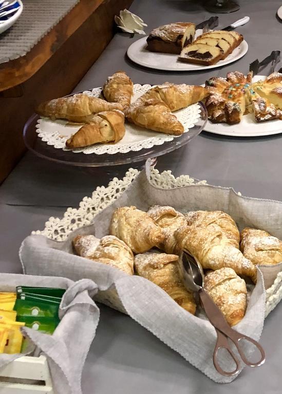 Rôzne pečivo ako croissanty a koláče vystavené na stole.