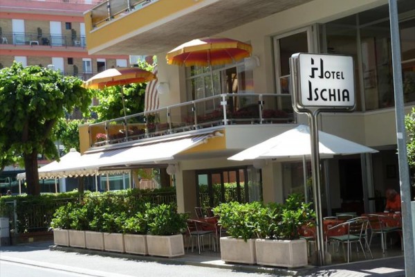 Hotel Ischia s vonkajším posedením a farebnými slnečníkmi.