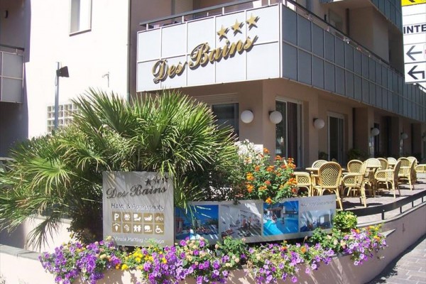 Vstup do hotela Des Bains s vonkajším posedením a kvetinovou výzdobou.