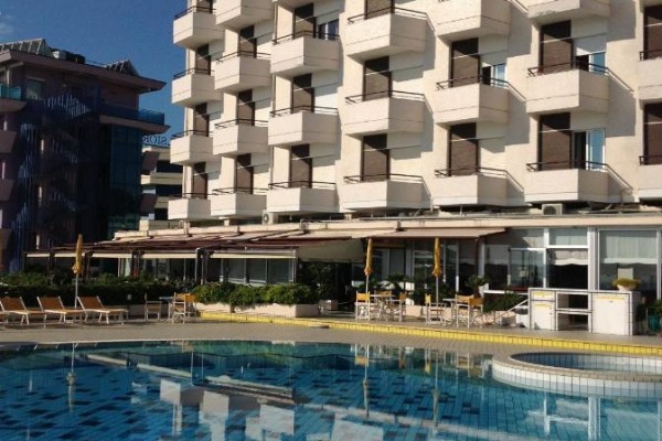 Hotel s balkónmi a bazénom v popredí.