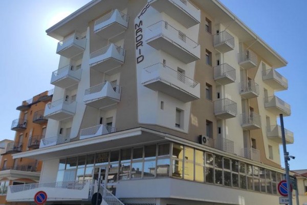 Moderná viacposchodová budova s balkónmi a nápisom 