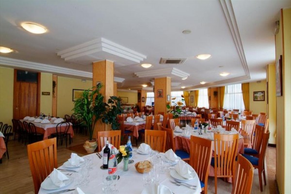 Elegantne prestretá reštaurácia s okrúhlymi stolmi a drevenými stoličkami.