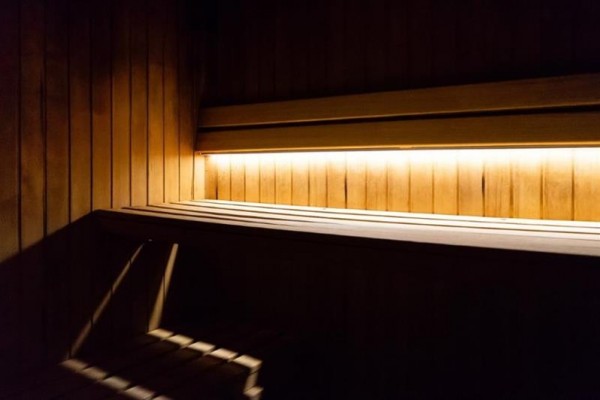 Drevený interiér sauny osvetlený teplým svetlom.  