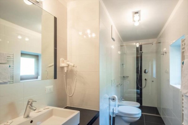 Moderná kúpeľňa s umývadlom, toaletou a preskleným sprchovým kútom.