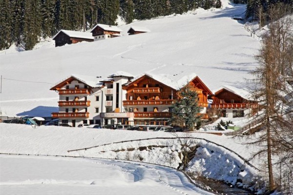 Horský hotel obklopený zasneženou krajinou.