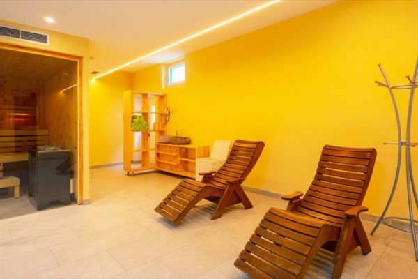 Relaxačná miestnosť s dvoma drevenými lehátkami a saunou.