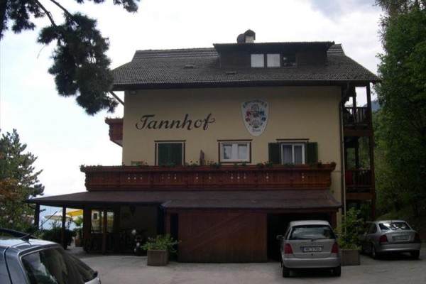 Budova s nápisom „Tannhof“ a zaparkovanými autami pred ňou.