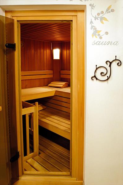 Drevená sauna s lavicami a osvetlením vo vnútri.