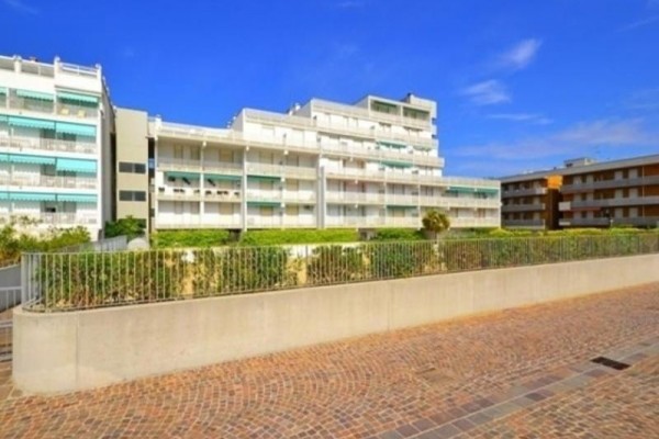 Moderný bytový komplex s balkónmi za slnečného dňa.