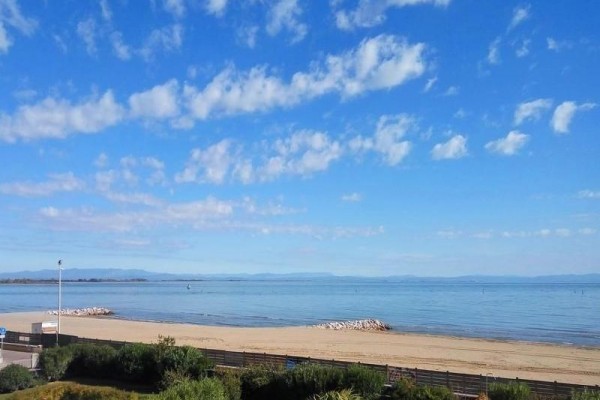 Pláž s výhľadom na pokojné more a modrú oblohu.