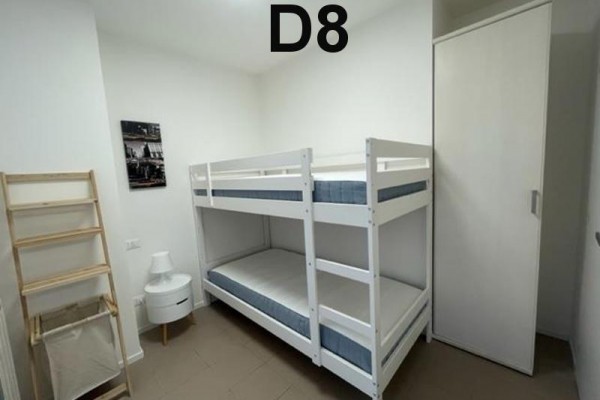 Zelená terasa s plastovým stolom a stoličkami, prepojená s kuchyňou.