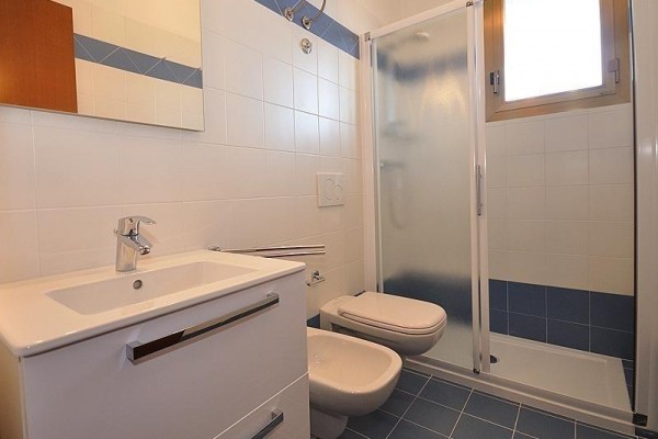 Moderná kúpeľňa s umývadlom, toaletou a sprchovacím kútom.  